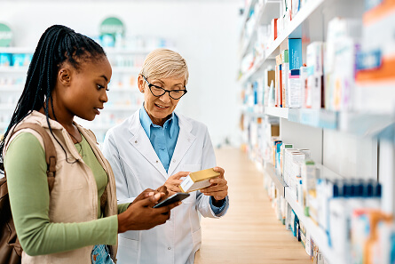 Assistant guiding a U.S. patient through a professional pharmacy abroad during a medical tourism visit.