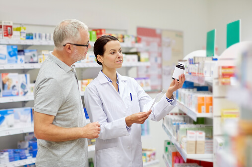 Patient entering a modern pharmacy in Tijuana to access specialty medications, greeted by a pharmacist in a professional and safe environment.