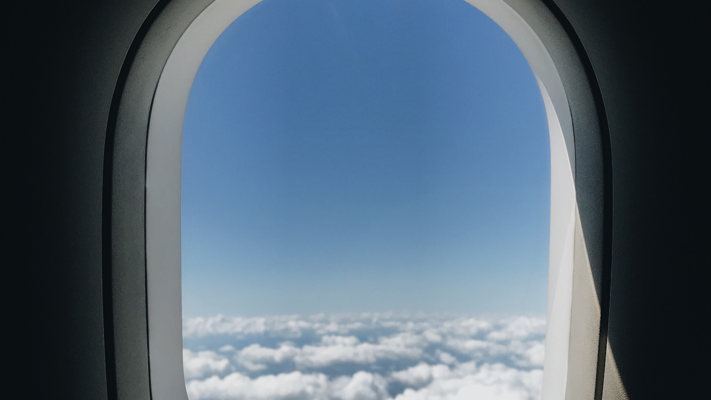 View of clouds through an airplane window on the flight to San Diego