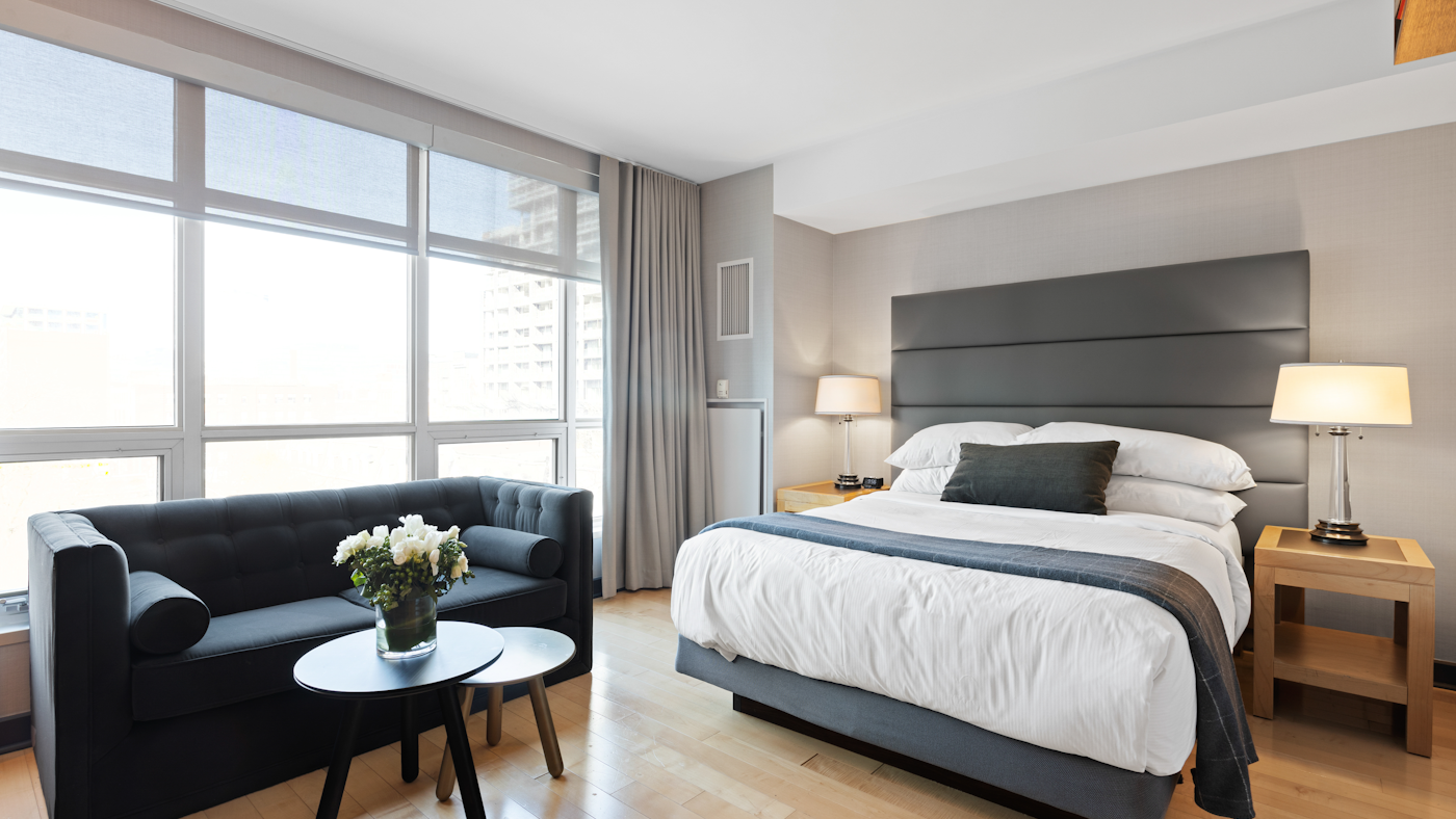 Bright, modern hotel room with a comfortable bed and city view